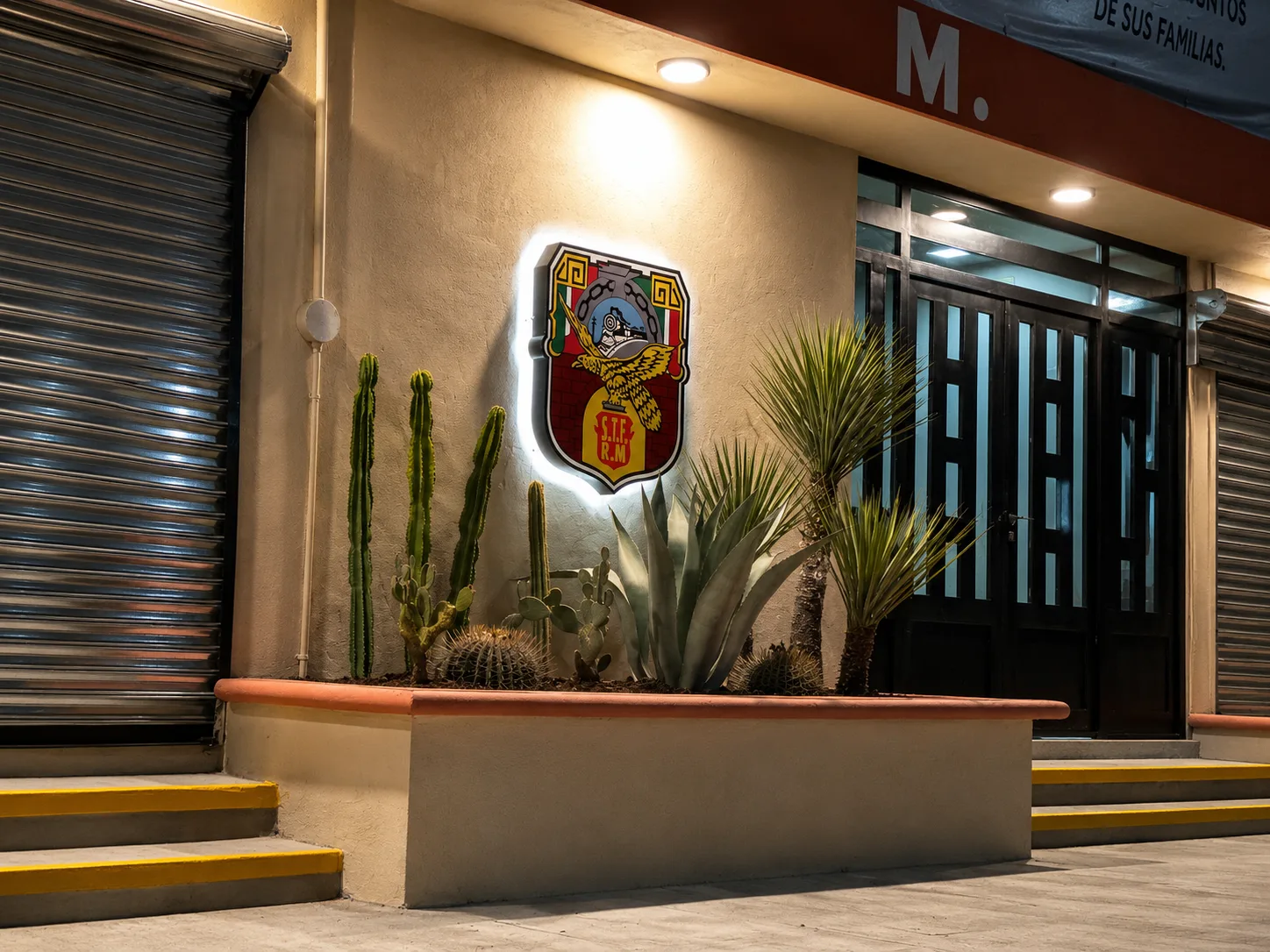 Fachada terminada con cancelería, escudo institucional y jardinera